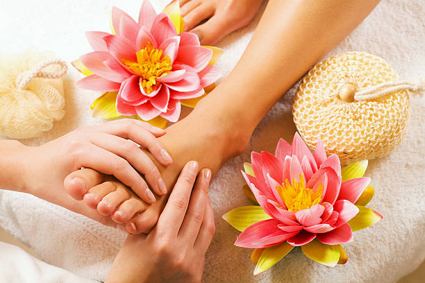 Woman enjoying a feet massage in a spa setting (close up on feet)